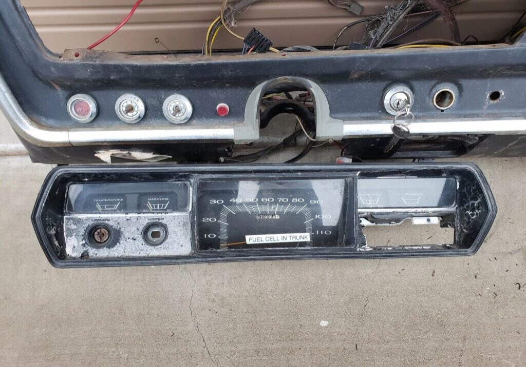 Old vehicle dashboard with speedometer removed.