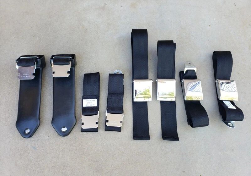 Black seatbelt buckles lined up on ground.