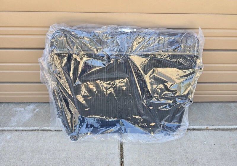 Plastic-wrapped radiator against a beige wall.