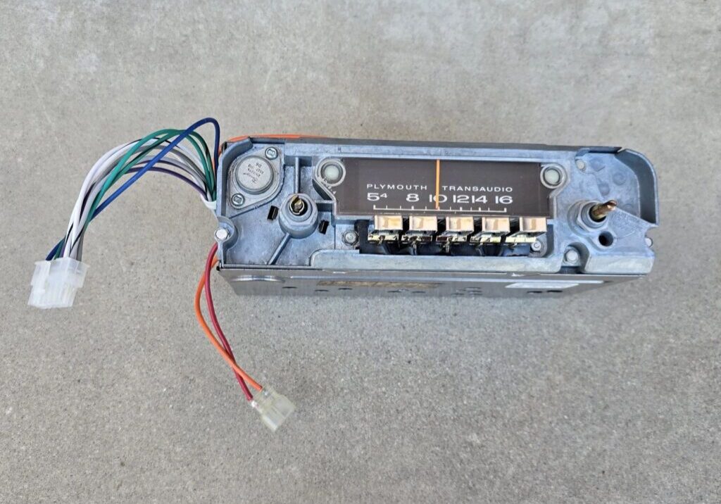 Vintage car radio with exposed wiring.