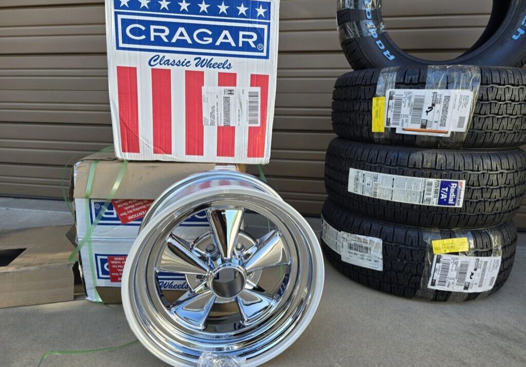 Chrome wheel and stacked tires near boxes.