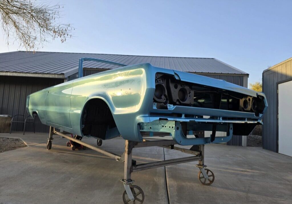 Vintage car body on a wheeled stand.