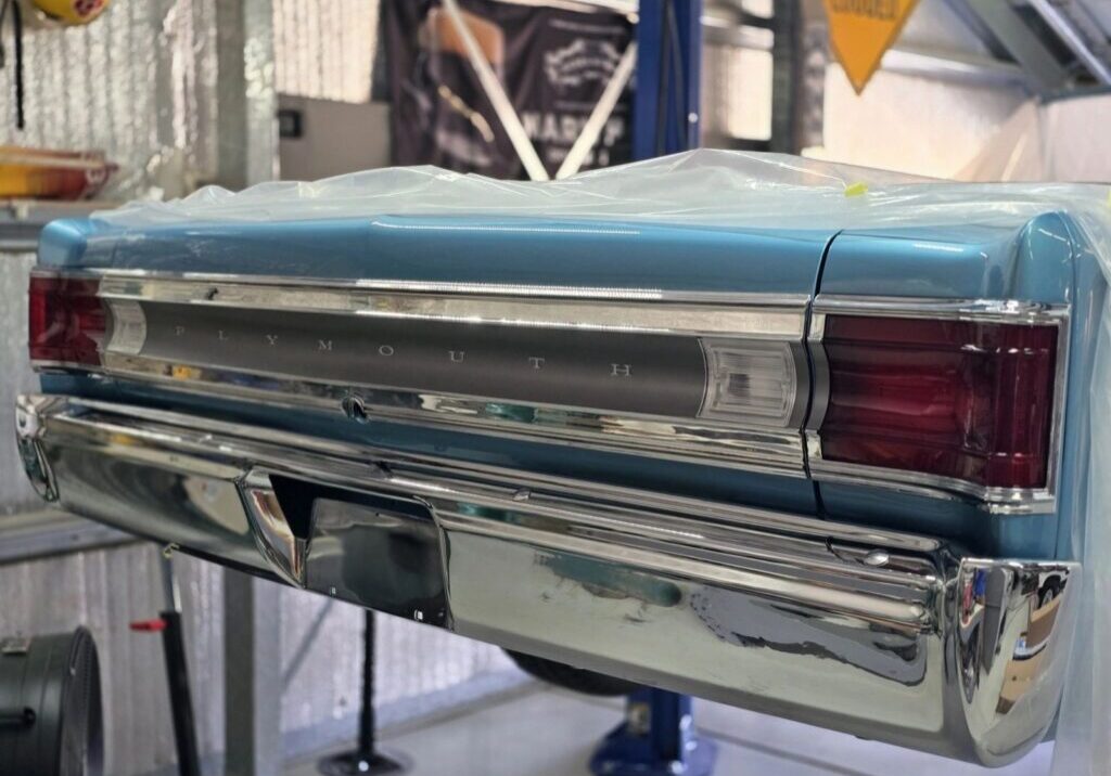 Classic Plymouth car rear in garage setting.