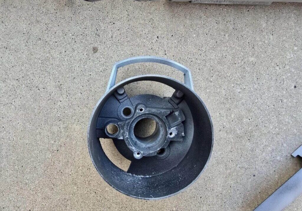 Round metal part on concrete surface.