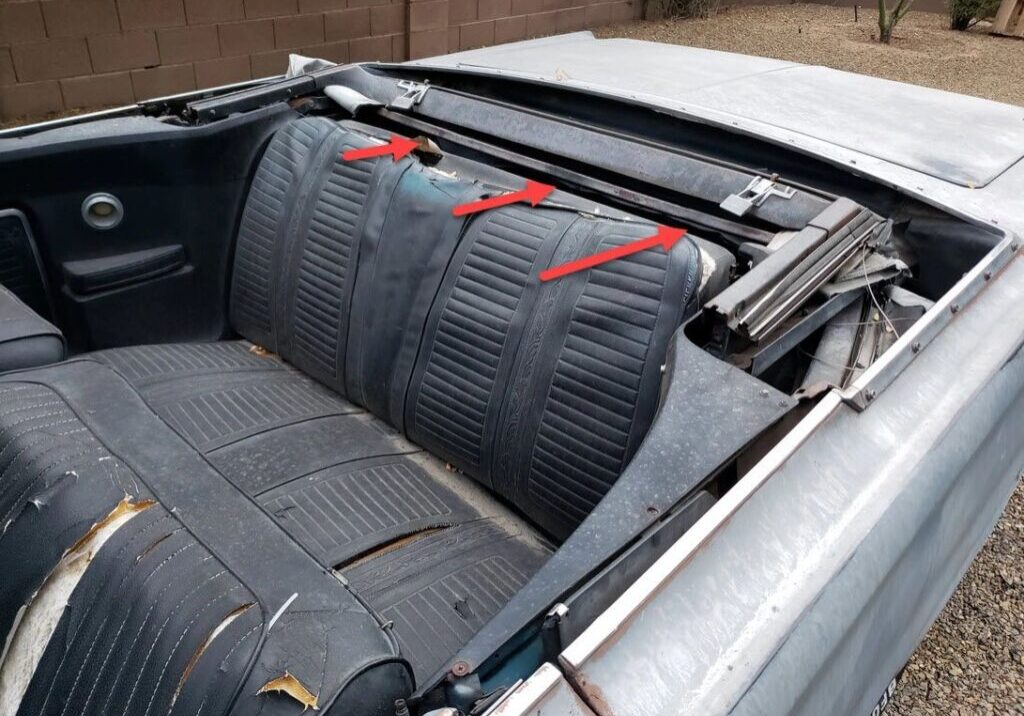 Convertible car interior with damaged backseat.