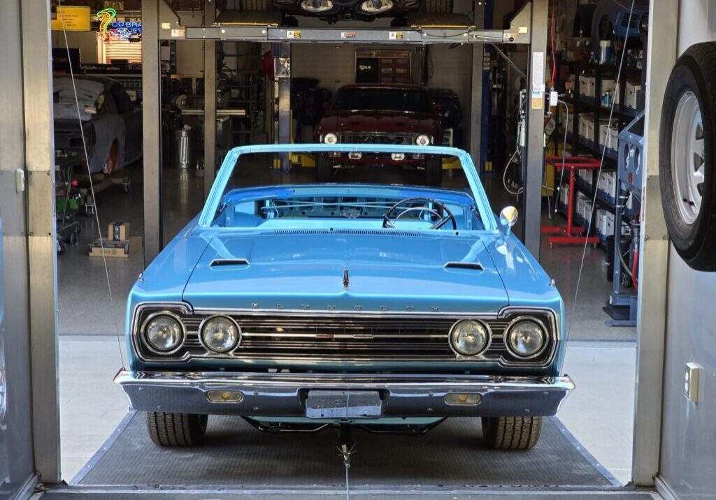 Blue vintage convertible car in a garage.