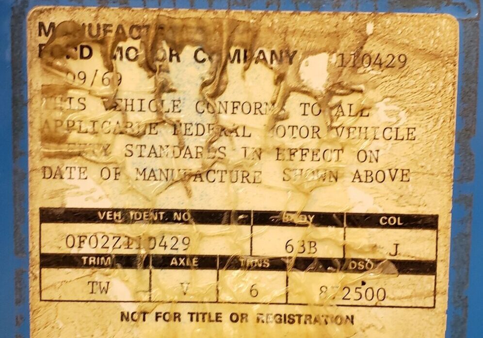 Vehicle identification sticker on blue surface.