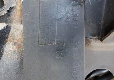 Metal plate attached to a car frame.