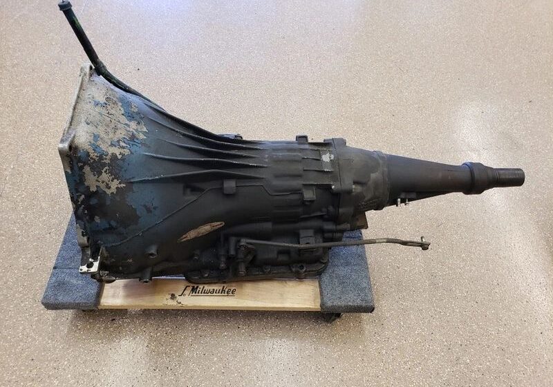 Old car transmission on wooden base.