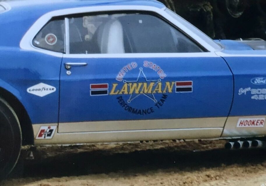 Blue vintage race car with "Lawman" logo.