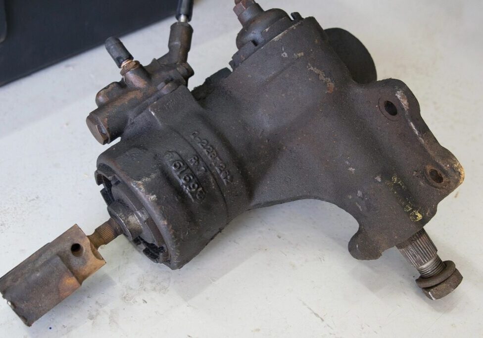 Old rusted mechanical part on white surface.