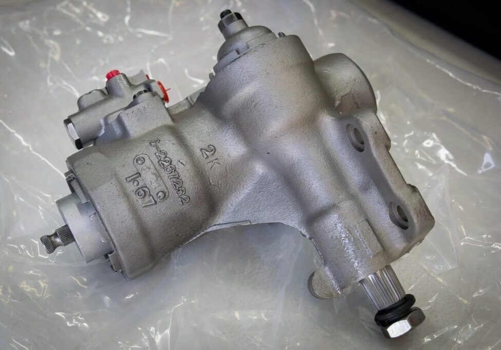 Silver automotive part on a plastic sheet.