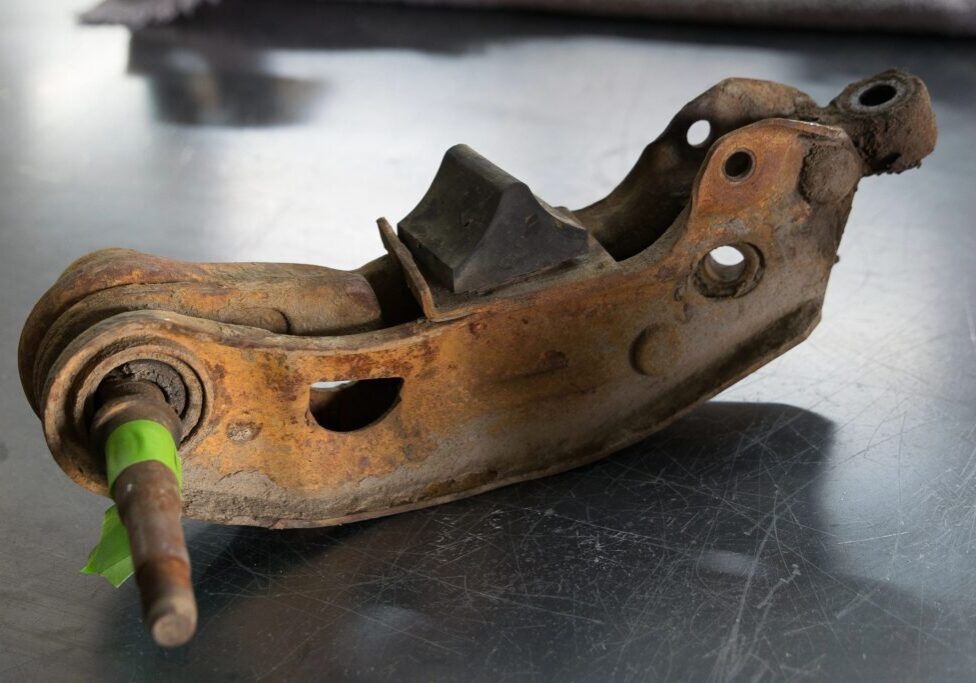 Rusty metal car part on a table.