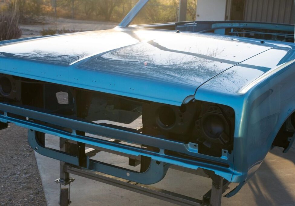 Blue car chassis without front bumper.