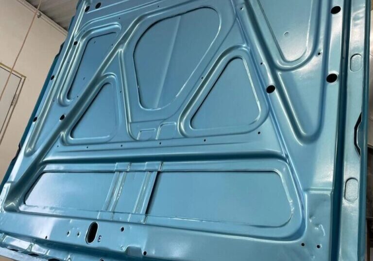 Blue car hood hanging in garage.