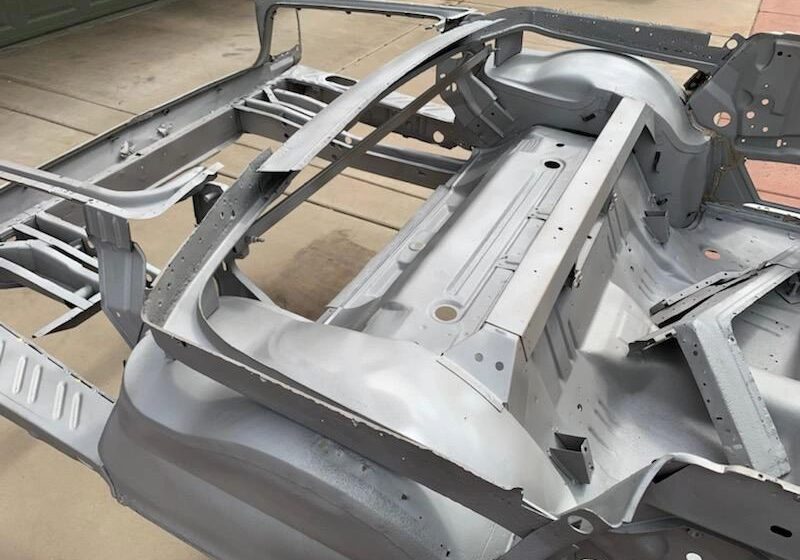 Car chassis frame on concrete surface.