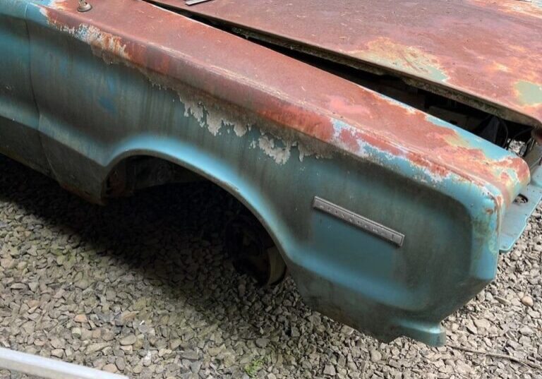 Rusty vintage car in a scrapyard.
