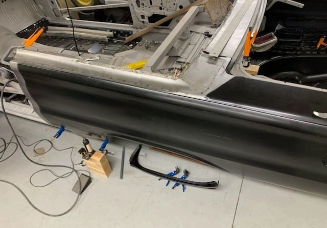 Car restoration project with tools and clamps.