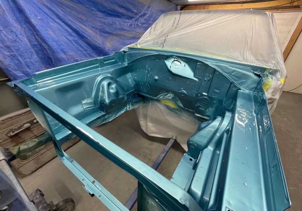 Car engine bay painted metallic blue.