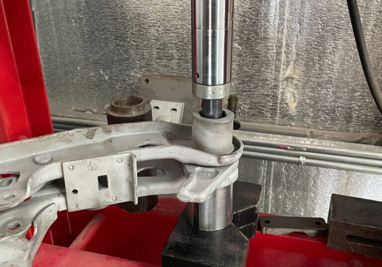 Hydraulic press working on metal component.