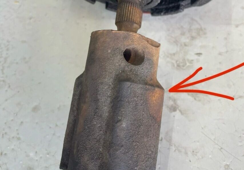 Rusty mechanical part with red arrow pointing.