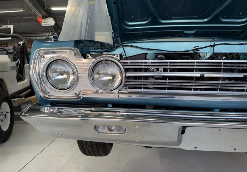 Classic blue car with hood open.