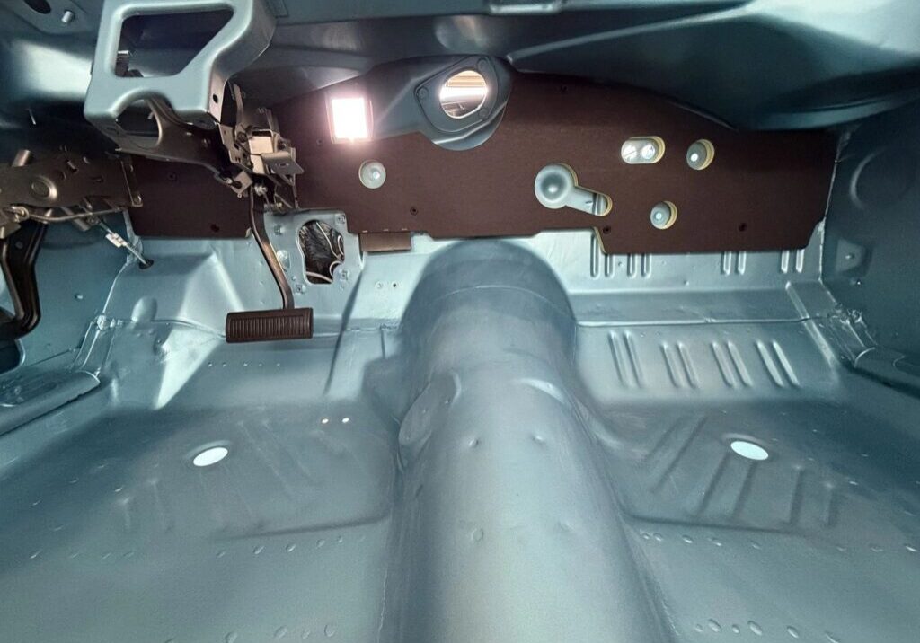 Car interior showing exposed metal floor.