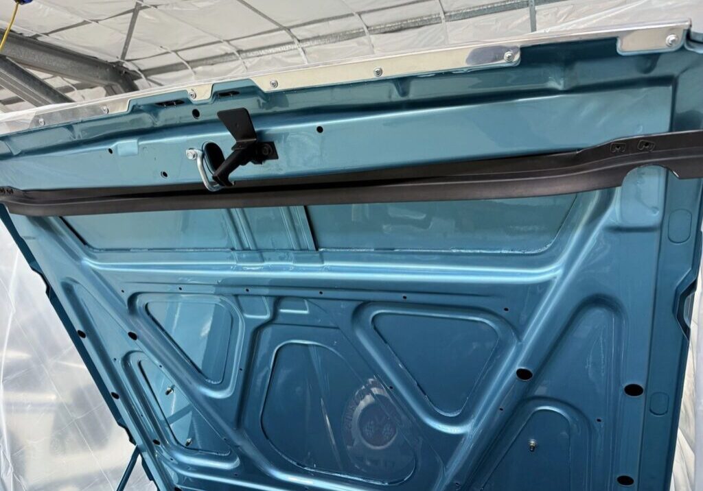 Blue car trunk interior with latch mechanism.