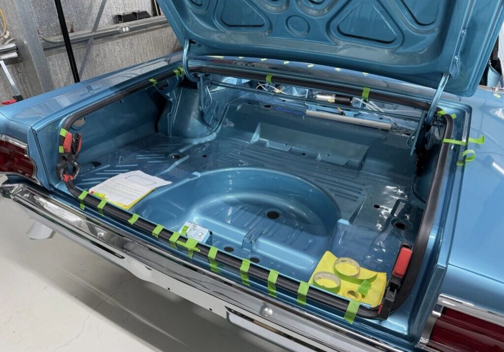 Open trunk of a vintage blue car.
