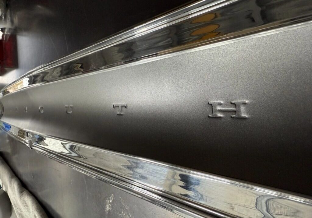 Chrome car emblem with embossed letters.