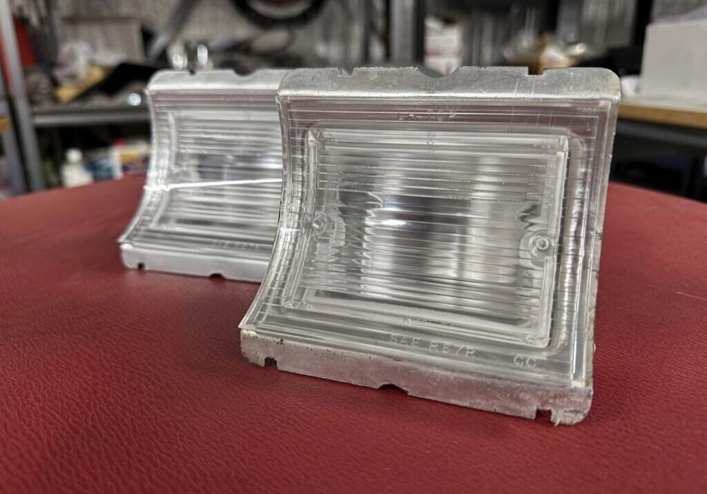 Two clear molded plastic automotive lenses.