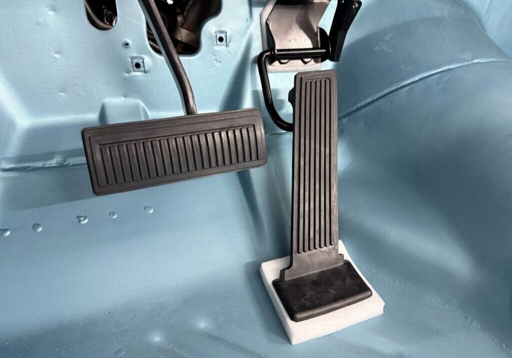 Car pedals on a blue vehicle floor.