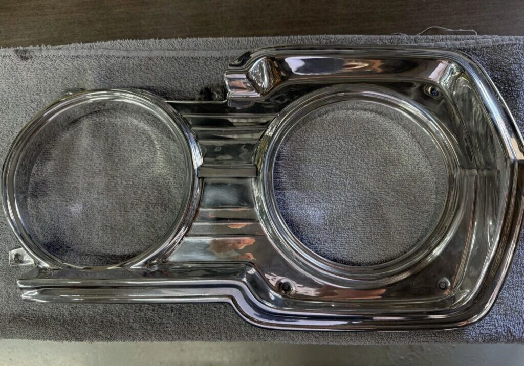Car headlight bezel on gray towel.