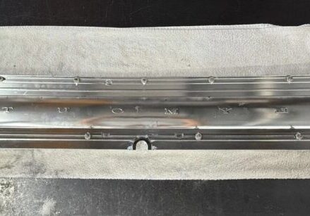 Metal component on white cloth surface.