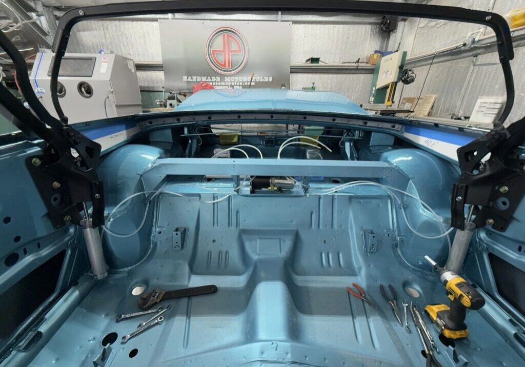 Car interior under restoration with tools.